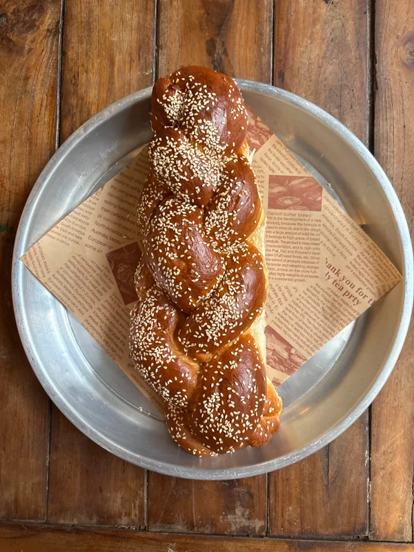 חלה קלועה טרייה עם שומשום על מגש / Fresh braided challah with sesame seeds