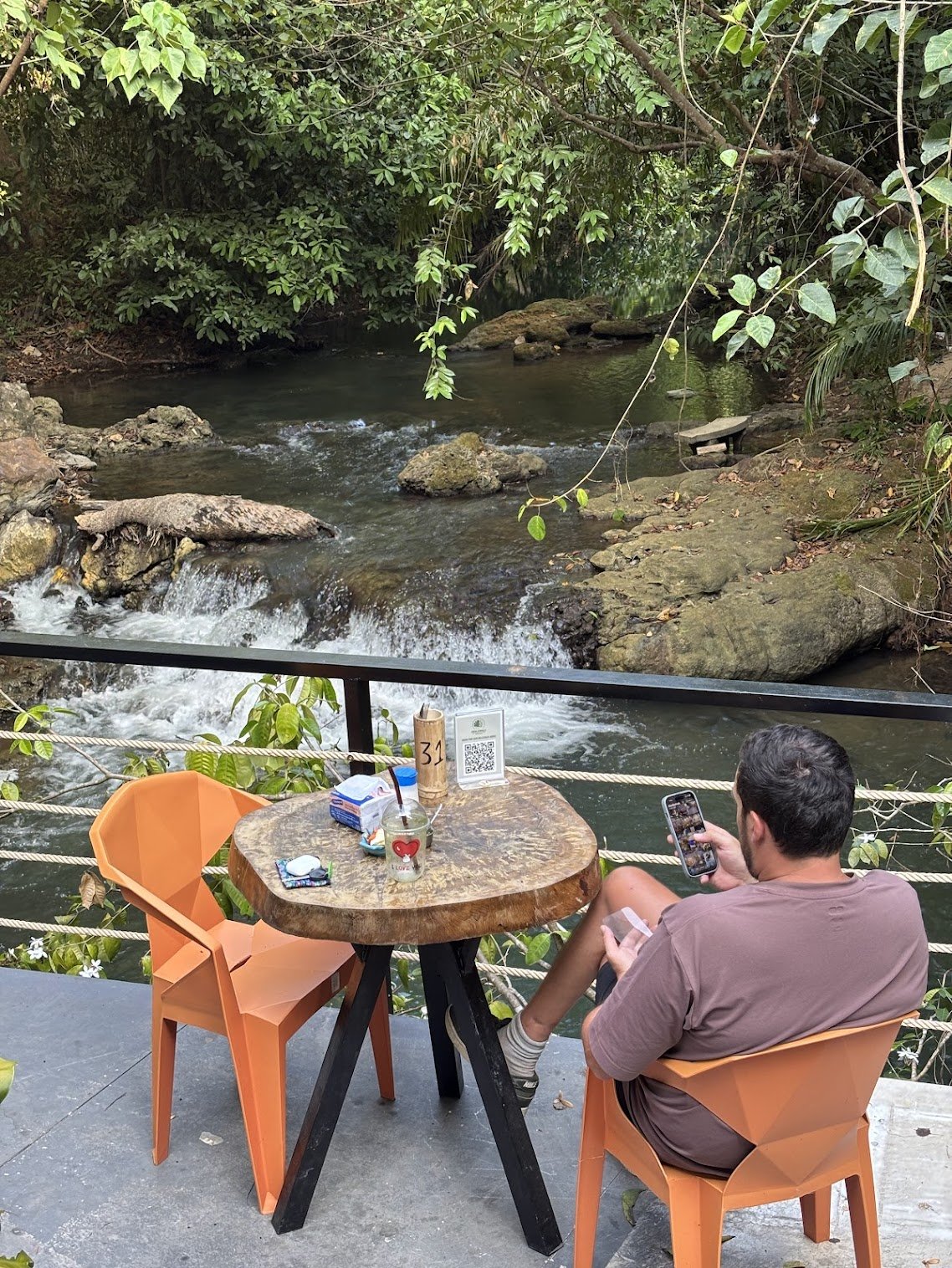 שולחן ליד מפל טבעי במסעדת MediJungle